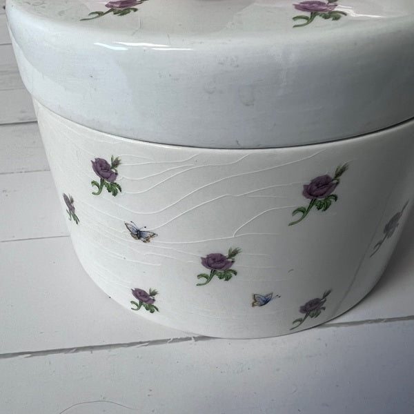 White container with floral designs on a white floor