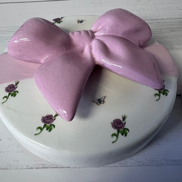 Pink bow-shaped object on a decorative plate with floral patterns
