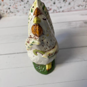 Decorative ceramic rooster figurine on a white surface