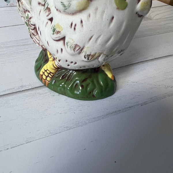 Ceramic rooster figurine on a white wooden surface