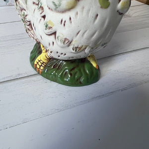 Ceramic rooster figurine on a white wooden surface