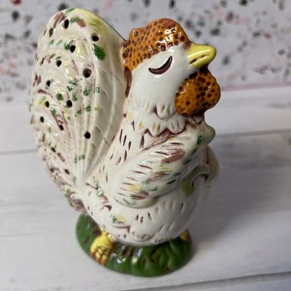 Ceramic chicken figurine on a textured surface