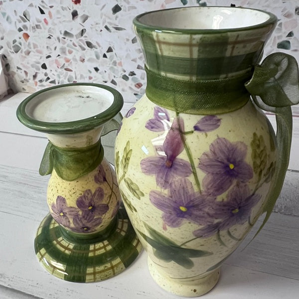 Ceramic vase and candle holder with floral design on a textured surface