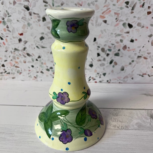 Decorative ceramic candle holder with floral design on a textured surface