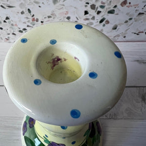 Ceramic candle holder with blue polka dots on a textured surface