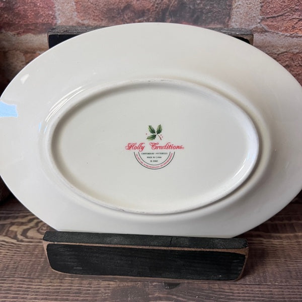 White oval plate with a logo on a wooden stand