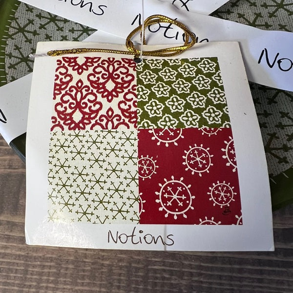 Card with red, green, and white patterned design on a wooden surface