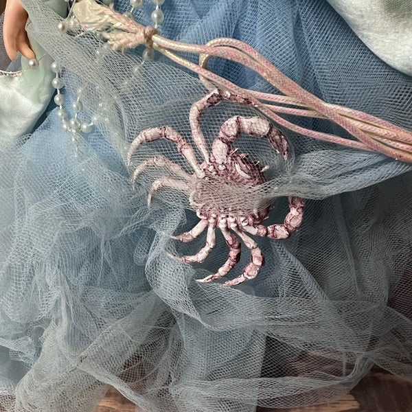 Decorative crab ornament on a sheer fabric doll dress