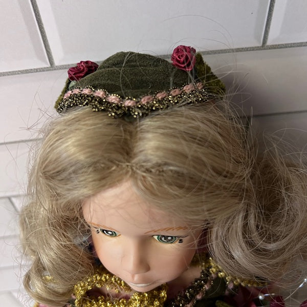 Close-up of a doll with blonde hair and a green headband against a white tiled wall.