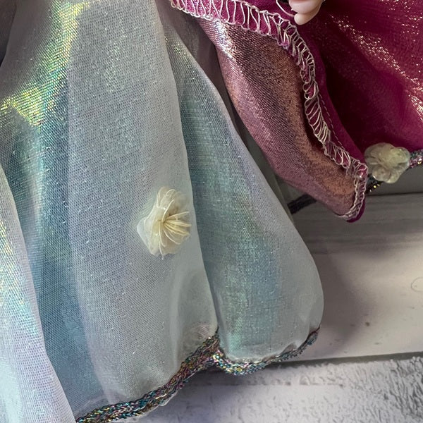 Close-up of a doll wearing a sheer silver skirt.