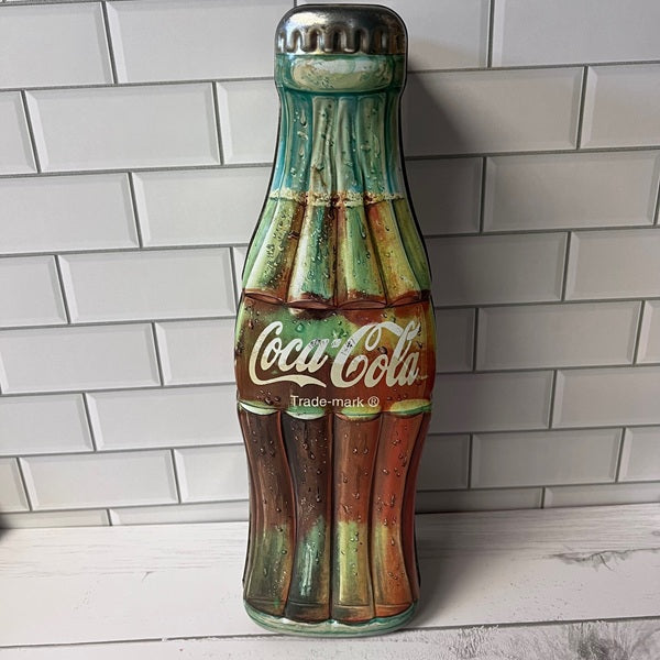 Decorative wall art of a vintage Coca-Cola bottle against a tiled wall.