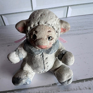 Vintage stone or concrete sheep figurine on a white surface