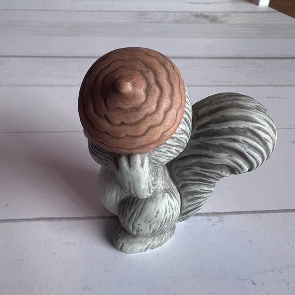 Squirrel figurine with a nut on a light wooden surface