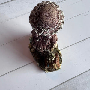 Decorative figurine with intricate details on a white wooden surface
