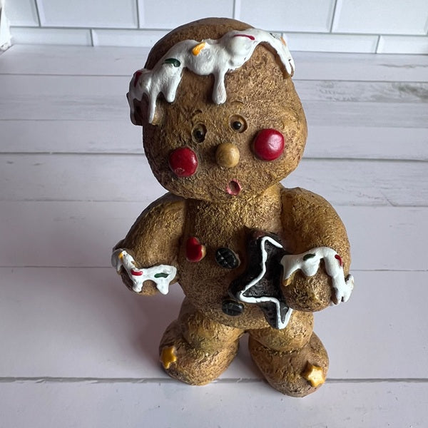 Gingerbread man figurine with icing on a white wooden surface