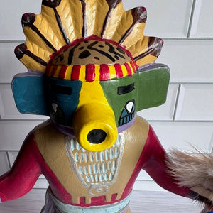 Colorful Native American-style headdress with a face mask on a white tiled background