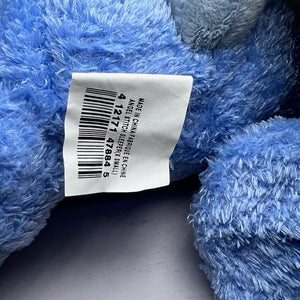 Blue plush toy with a label showing a barcode and text.