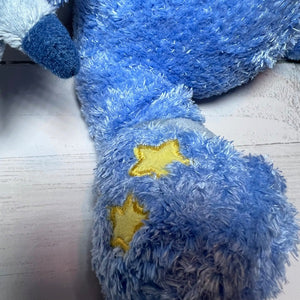 Blue plush toy with yellow stars on a light wooden floor