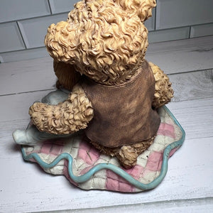 Vintage teddy bear on a checkered cushion with a white tiled wall background