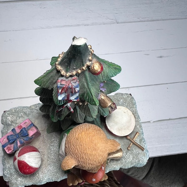 Decorative Christmas tree figurine with ornaments on a white wooden surface