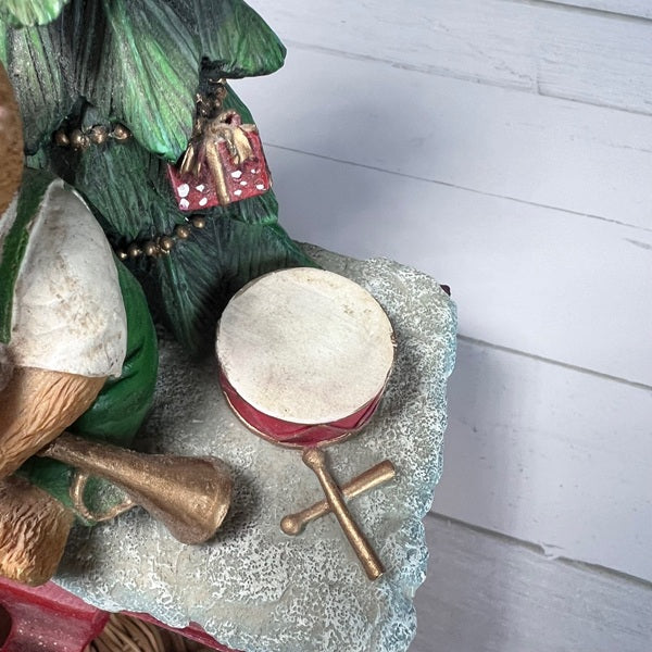 Decorative figurine with a drum, cornet, and green tree on a white surface