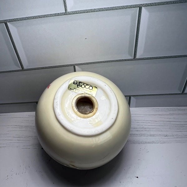 Round beige object with a label on a tiled floor