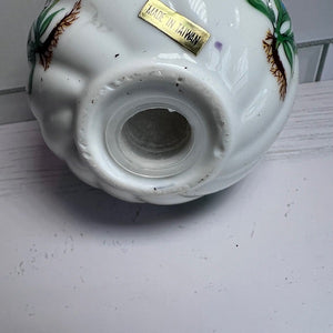 Ceramic item with decorative elements and 'Made in Taiwan' label on a white surface