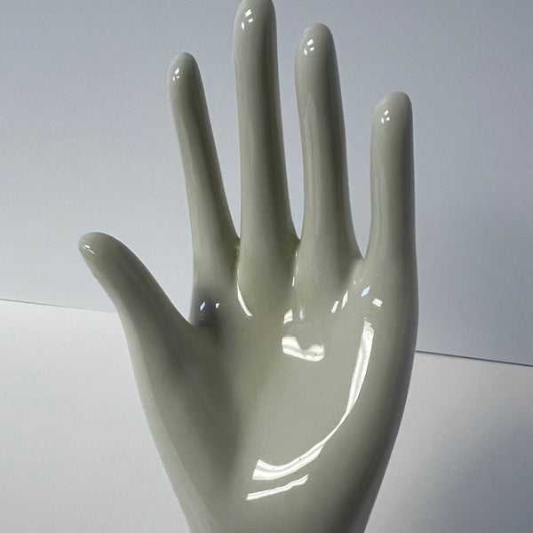 Glossy ceramic hand sculpture on a white background