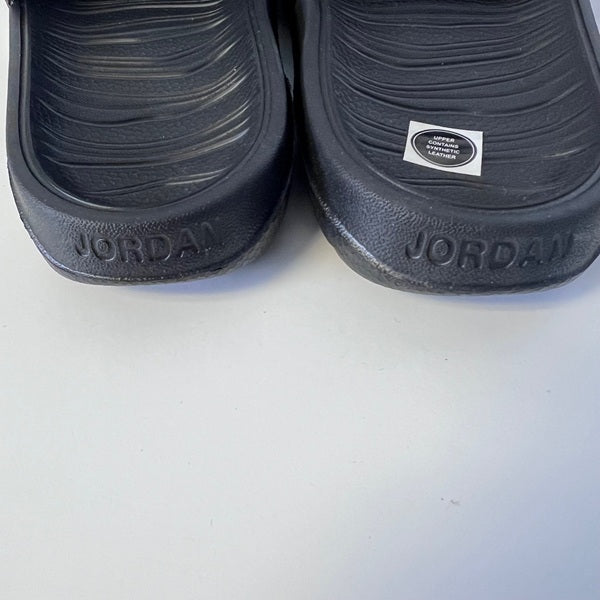 Black Jordan sandals on a white background
