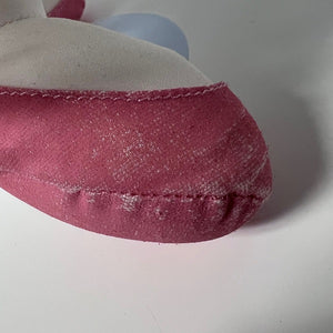Close-up of a pink fabric item with visible stitching on a white background