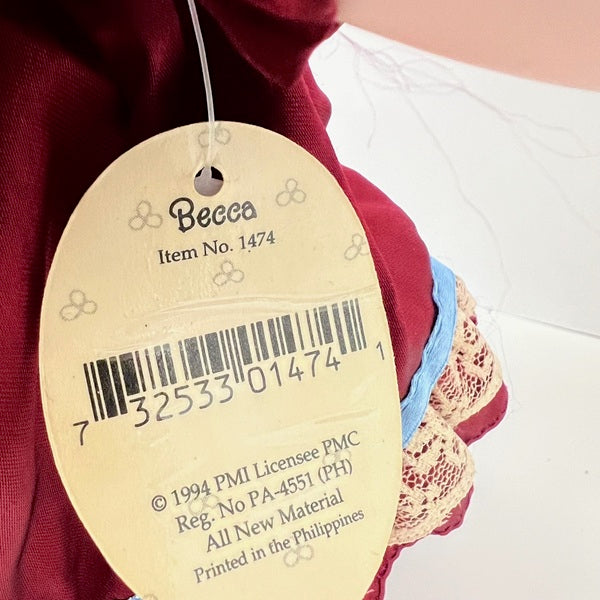 Becca doll product tag on a garment with a barcode and text