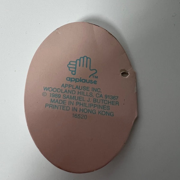 Round brown label with green text and 'applause' logo on a white background
