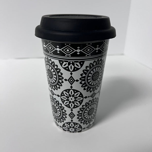 Black and white patterned travel mug with a black lid on a white background