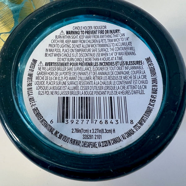 Close-up of a candle label with text and a barcode on a white background