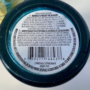 Close-up of a candle label with text and a barcode on a white background