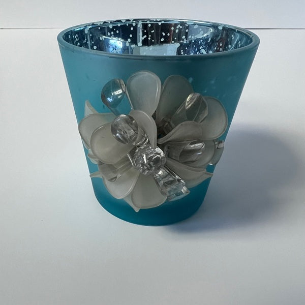 Blue candle holder with decorative flowers on a white background