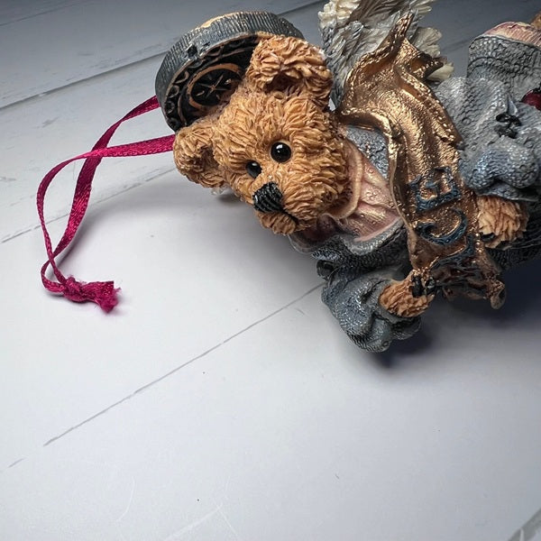 Decorative bear ornament with a hat and scarf on a white surface