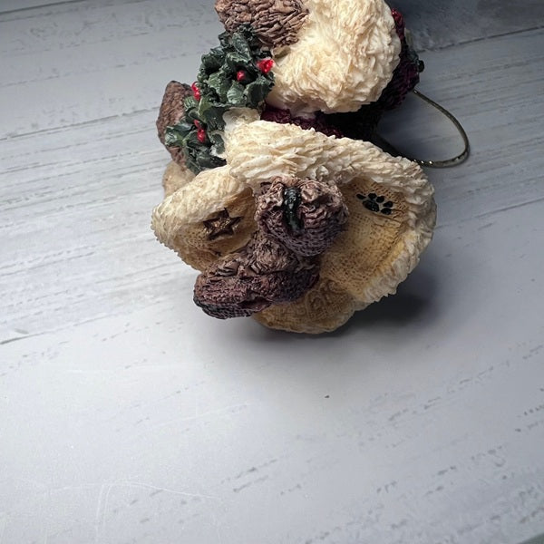 Decorative ornament resembling a bear with a Christmas wreath on a white surface