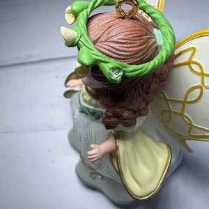 Decorative angel figurine with green hair accessory on a light background