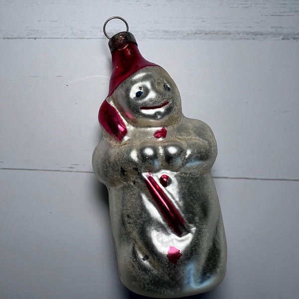 Vintage glass snowman ornament with a red hat and scarf on a white background
