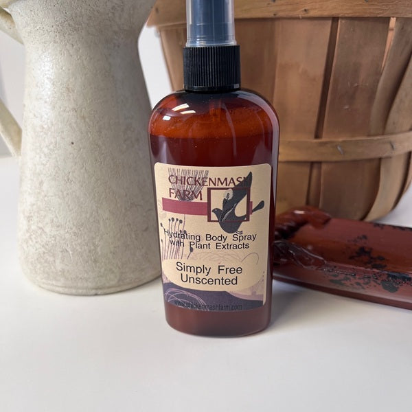 Bottle of Chickenman's Farm body spray on a white surface with a wooden basket in the background.