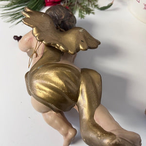 Decorative figurine of a child with gold outfit and headpiece on a white background