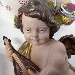 Statue of an angel holding an instrument with a white background