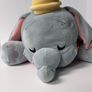 Plush toy elephant with a small yellow character on top against a light gray background