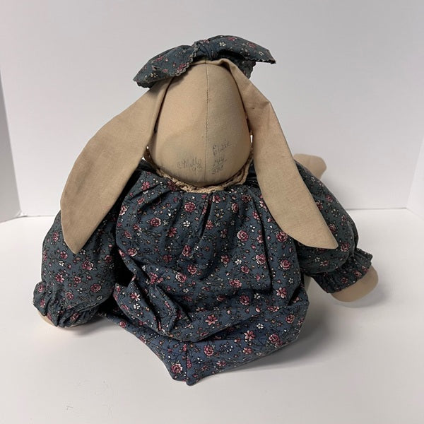 Vintage-style rabbit plush decor with floral dress on a white background