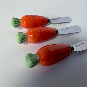 Three carrot-shaped knives with stainless steel blades on a white background