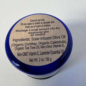 Blue container with a botanical salve ingredients label on a white background