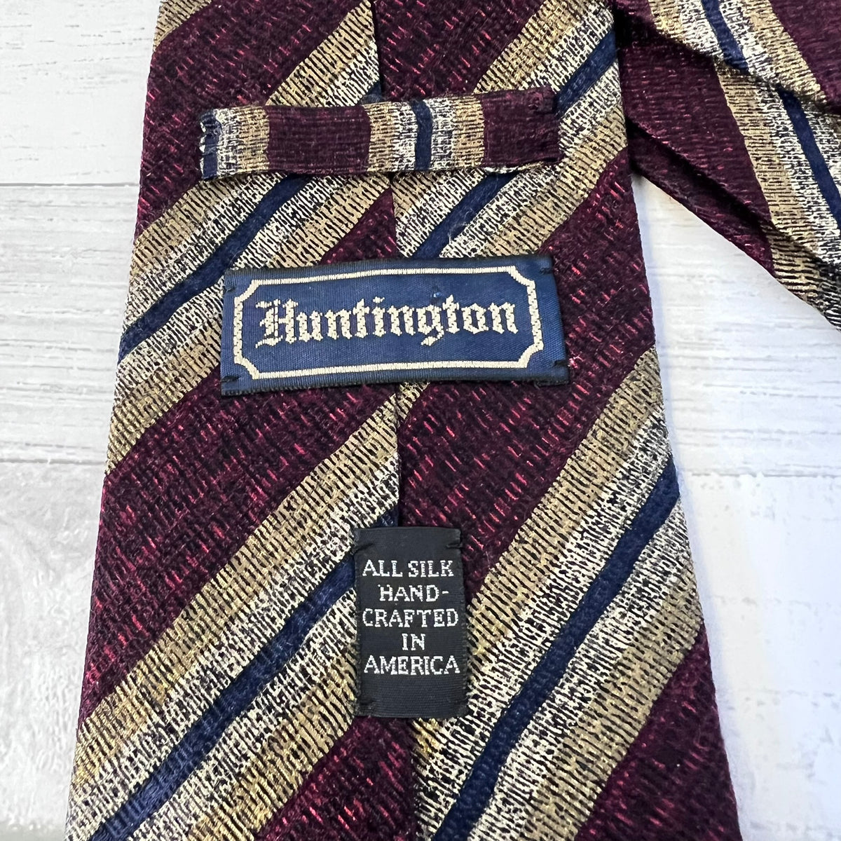 Striped tie with 'Huntington' label on a white background