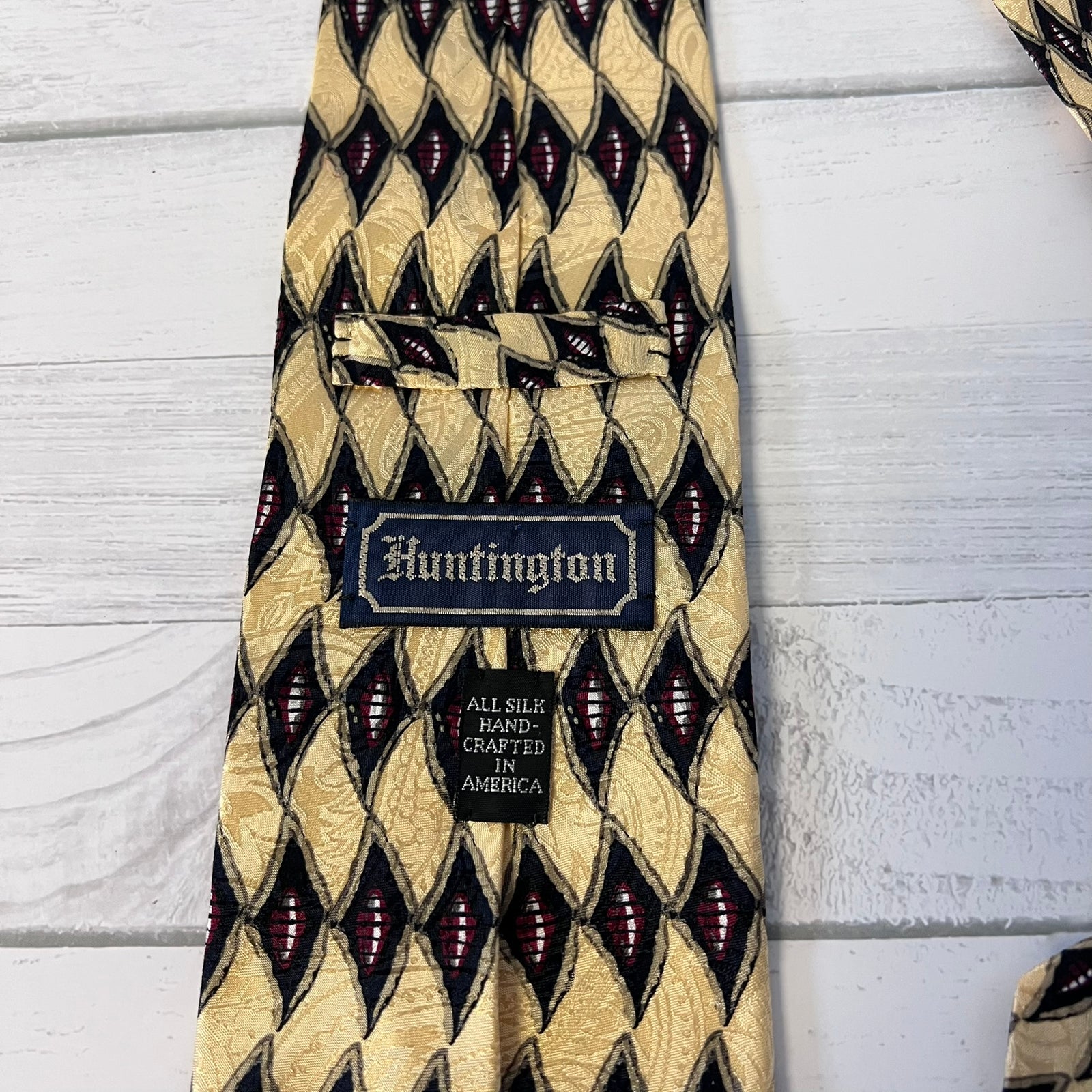 Patterned tie with 'Huntington' label on a light wooden surface