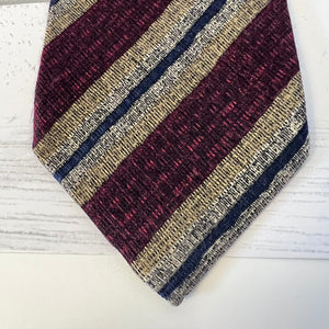 Striped tie with maroon, beige, and navy pattern on a white surface